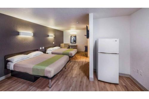 Una habitación de hotel con dos camas y un refrigerador. en Studio 6 Irving, TX - Irving DFW Airport East, en Irving