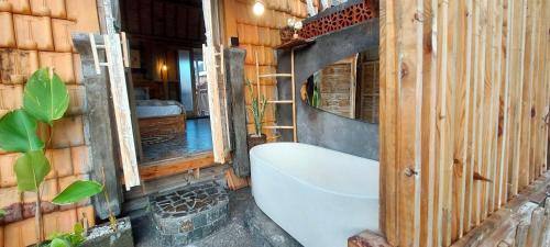 a bathroom with a bath tub in a building at Wisnu Lumbung Uluwatu in Uluwatu
