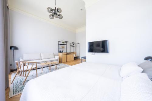 a white bedroom with a bed and a couch at Zámek Načeradec in Načeradec