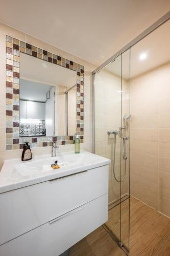 une salle de bain avec un lavabo et une douche dans l'établissement L'Écrin de Pierre dans un cadre de vie unique, à Saint-Laurent-du-Var