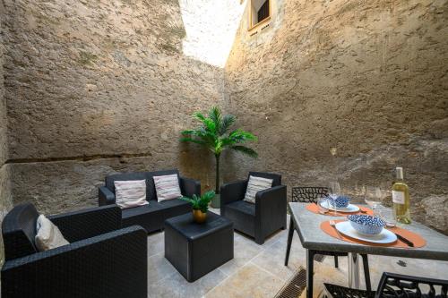 une terrasse avec des canapés, une table et des chaises dans l'établissement L'Écrin de Pierre dans un cadre de vie unique, à Saint-Laurent-du-Var
