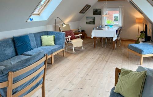 a living room with a blue couch and a table at Cozy Home In Stubbekøbing With Kitchen in Stubbekøbing