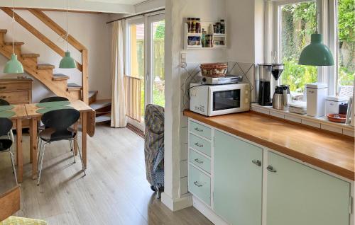 a kitchen with a counter with a microwave and a table at Cozy Home In Stubbekøbing With Kitchen in Stubbekøbing