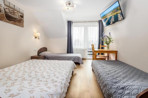 a hotel room with two beds and a window at Willa Wilk Morski in Jastrzębia Góra