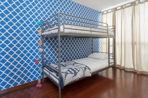 a bunk bed in a room with a blue wall at Casa do Lugar de Baixo in Ponta do Sol