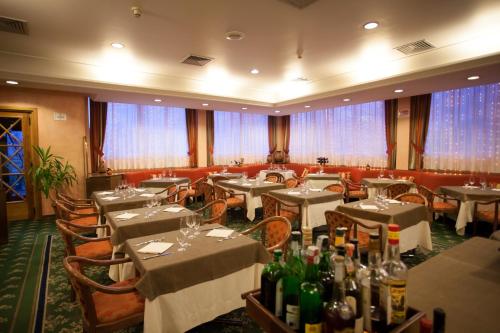 a restaurant with tables and chairs with bottles of wine at Etrusco Arezzo Hotel - Sure Hotel Collection by Best Western in Arezzo