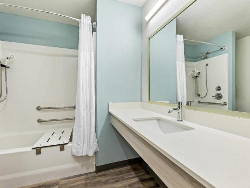 a bathroom with a sink and a mirror at WoodSpring Suites Prattville - Montgomery North in Prattville