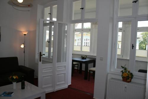 a room with a door with a table and windows at Ferienwohnung Villa Dora, Seebad Ahlbeck in Ahlbeck