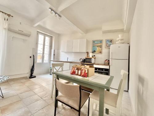 une cuisine avec une table avec des chaises et un réfrigérateur dans l'établissement Cannes 2 Bedroom Apartment - 19JDR2, à Cannes