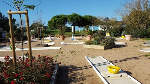 a park with a playground with plants and flowers at Appartement l'Archipel - Vue mer exceptionnelle et bassins aquatiques du 29 avril au 15 sept in Talmont