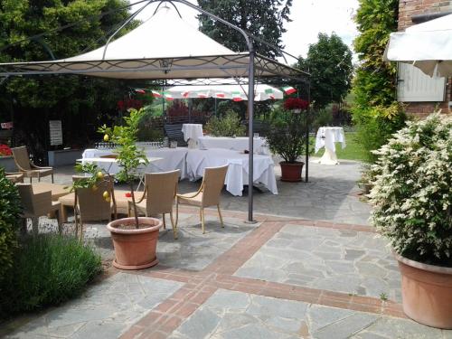 a patio with a table with white tables and chairs at Locanda del Boscogrande in Montegrosso dʼAsti