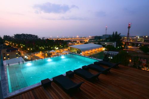 una piscina en la parte superior de un edificio por la noche en The Sixteenth Naiyang Beach Hotel SHA Plus en Nai Yang Beach