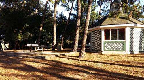 a picnic shelter with a picnic table in a park at Appartement l'Archipel - Vue mer exceptionnelle et bassins aquatiques du 29 avril au 15 sept in Talmont