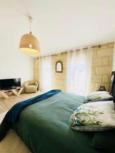 une chambre avec un grand lit et une télévision dans l'établissement La Bulle Médocaine - JACUZZI- Tout confort, à Macau