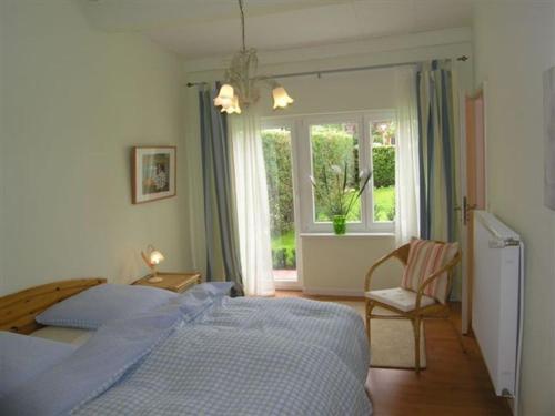 a bedroom with a blue bed and a window at Ferienhaus Friedrich-Borge-Straße in Kühlungsborn