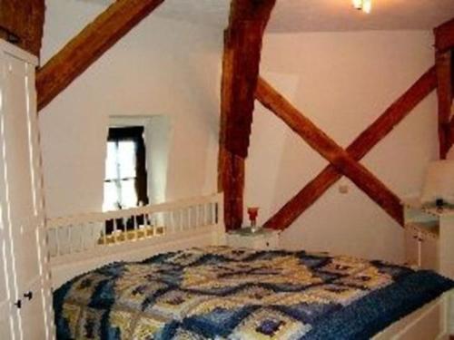 Schlafzimmer mit einem Bett in einem Zimmer mit Holzbalken in der Unterkunft Appartements An der Muehle in Brunshaupten