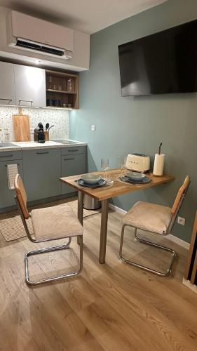 une cuisine avec une table, deux chaises et un comptoir dans l'établissement Exotic Garden - Studio cosy hypercentre Auxerre, à Auxerre