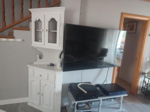 a kitchen with a tv and a counter with a desk at casa con piscina Comarruga in Comarruga