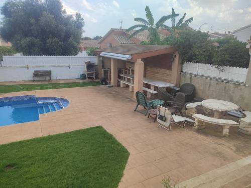 a patio with a table and chairs and a pool at casa con piscina Comarruga in Comarruga