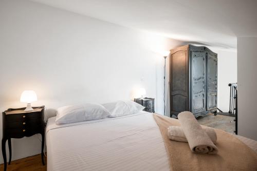 une chambre avec un grand lit blanc avec des serviettes dessus dans l'établissement Évasion en duplex au cœur de la vieille ville, à Saint-Laurent-du-Var