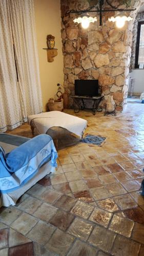 a living room with two beds and a stone wall at Rustic-style apartment in LMP