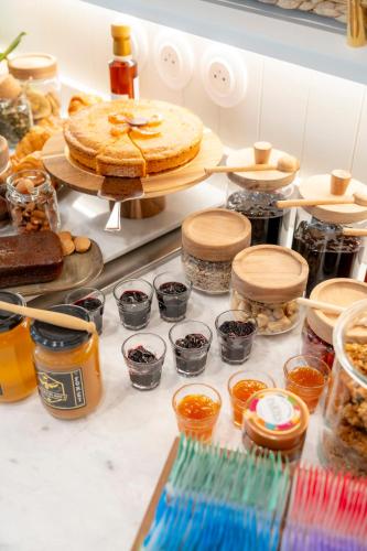 a table with a cake and jars of preserves at Le Petit Hôtel in Saint-Jean-de-Luz