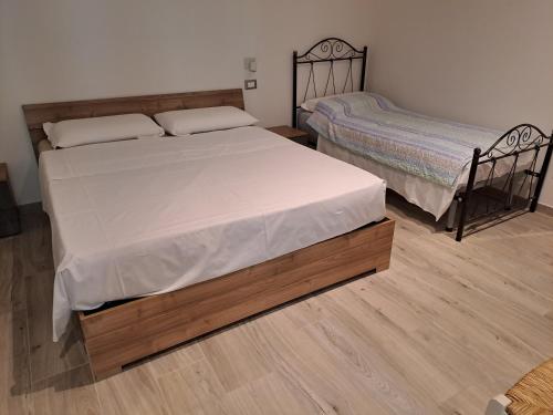 two beds in a room with wooden floors at Il Nido delle Cicogne in Sacca