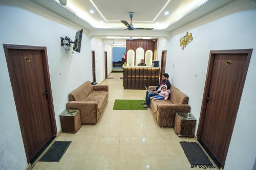 a man and a child sitting on a couch in a living room at Shri Bankey Bihari Guest House in Mathura