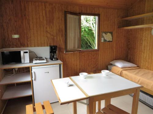 a small room with a table and a microwave at Aire Du Verger in Palluau