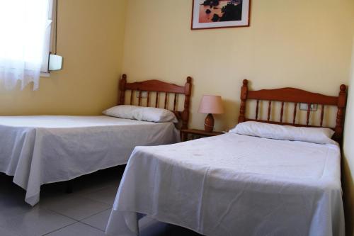 2 camas en una habitación con sábanas blancas en ROC MAR 3 3B - Apartamento cerca del centro y de la playa - terraza con vistas al mar y al puerto, en Roses