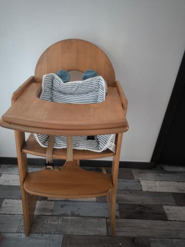une chaise en bois avec une table et des coussins dessus dans l'établissement Le Petit coin de Paradis, à Auxi-le-Château