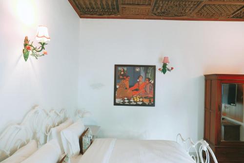 a bedroom with a bed and a picture on the wall at Neem Haveli in New Delhi