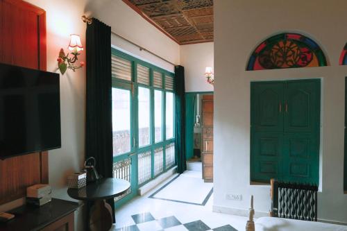 a room with a green door and a balcony at Neem Haveli in New Delhi