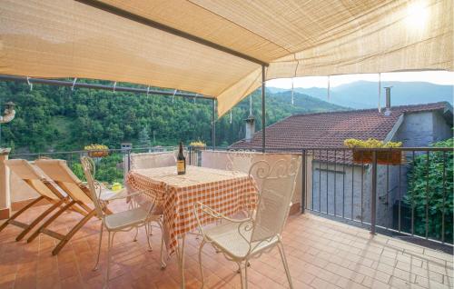 Un patio con una mesa y sillas en un balcón. en Gorgeous Home In Ponti Di Pornassio, en Ponte di Nava