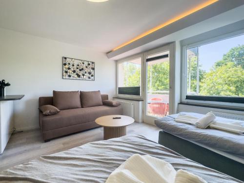 un salon avec deux lits et un canapé dans l'établissement Apartment für 4 Gäste mit Parkplätzen und Lift, à Hanovre