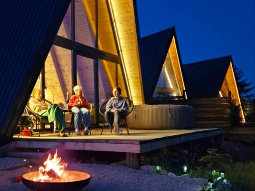 people sitting on the porch of a house with a fire at Hill House Žabljak in Žabljak