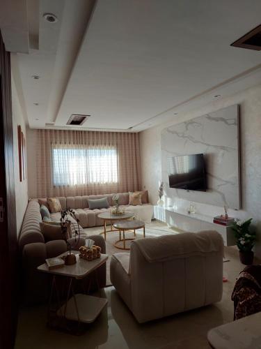 a large living room with couches and a tv at اجمل شقة in Temara