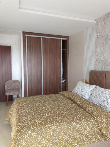 a bedroom with a large bed with a gold bedspread at اجمل شقة in Temara