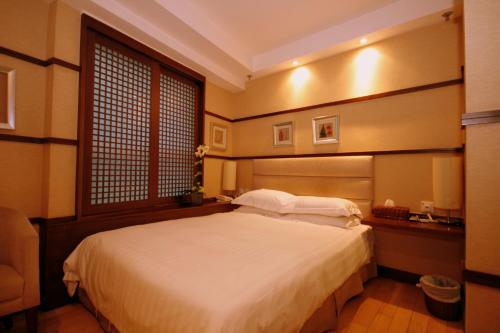 Schlafzimmer mit einem großen weißen Bett und einem Fenster in der Unterkunft Mingle At The Eden in Hongkong