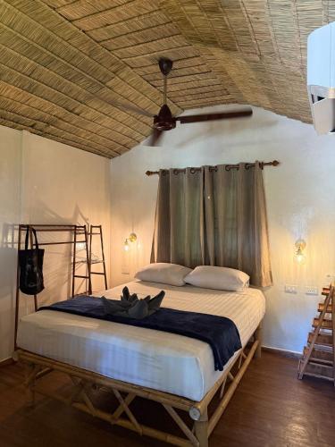 a bedroom with a large bed with a wooden ceiling at Colorful Hut in Haad Pleayleam