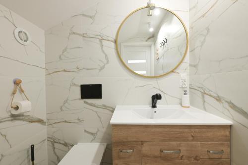 een badkamer met een wastafel en een spiegel bij Bałtyckie Tarasy by Q4Apartments in Władysławowo