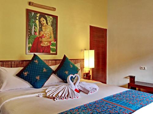 a hotel room with a bed with swans on it at Cocotinos Lembeh a Boutique Dive Lodge in Bitung