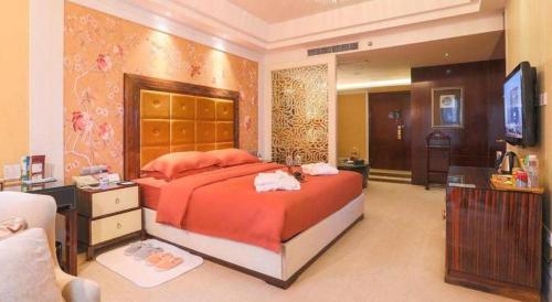a bedroom with a large bed and a television at Fortune International Hotel in Xiawutun