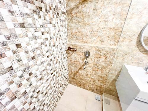 ein Bad mit einer Dusche und einem Waschbecken in der Unterkunft Mataram City 327 by We Stay in Kejayan