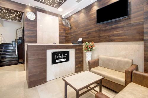 a waiting room with a chair and a tv on a wall at Collection O Vijayawada Near Railway Station in Vijayawāda