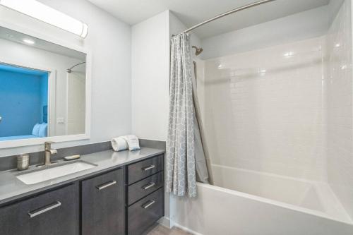 a bathroom with a tub and a sink and a shower at Luxe 1B|Pool|Marble Falls Escape in Marble Falls