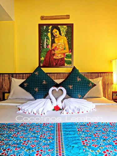 a bedroom with a bed with a painting of a woman at Cocotinos Lembeh a Boutique Dive Lodge in Bitung