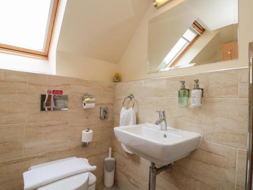 a bathroom with a sink and a toilet and a mirror at Clematis Cottage in Whitby