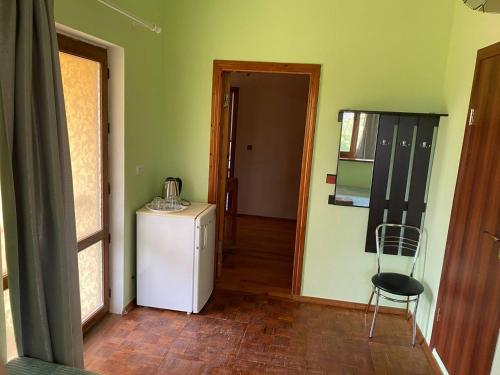 a hallway with a refrigerator and a chair in a room at Хуторок у Зіни in Sanzhiyka