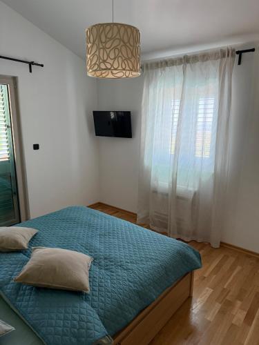 a bedroom with a bed with a blue comforter at Villa Maluso in Budva